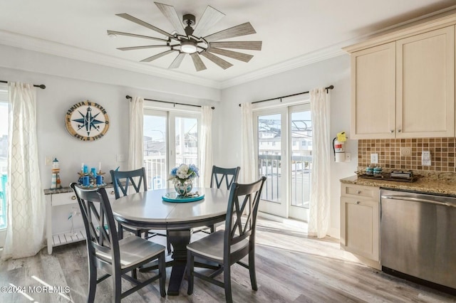 dining space featuring ceiling fan, light wood-type flooring, and crown molding