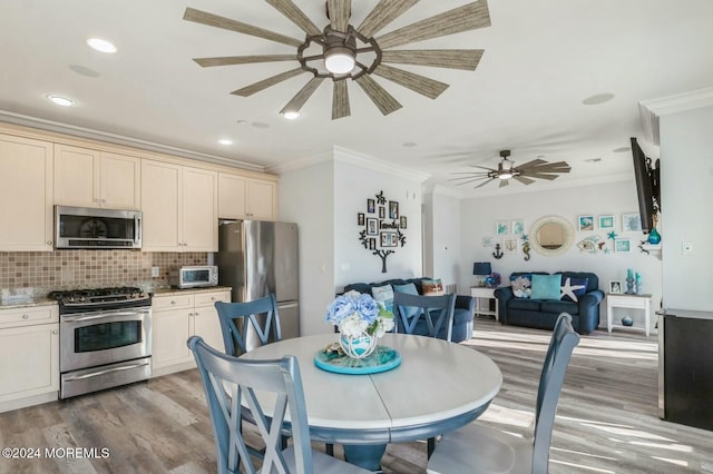 dining room featuring ceiling fan, wood-type flooring, and ornamental molding