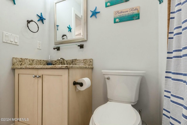 bathroom with a shower with curtain, vanity, and toilet