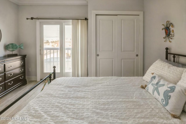 bedroom with access to outside, crown molding, a closet, and wood-type flooring