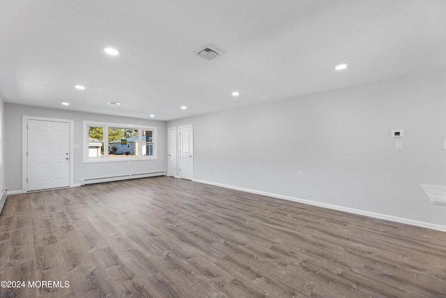 unfurnished living room with light wood-type flooring and baseboard heating