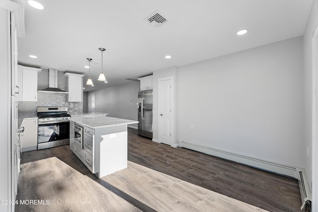 kitchen featuring white cabinetry, stainless steel appliances, wall chimney range hood, tasteful backsplash, and decorative light fixtures