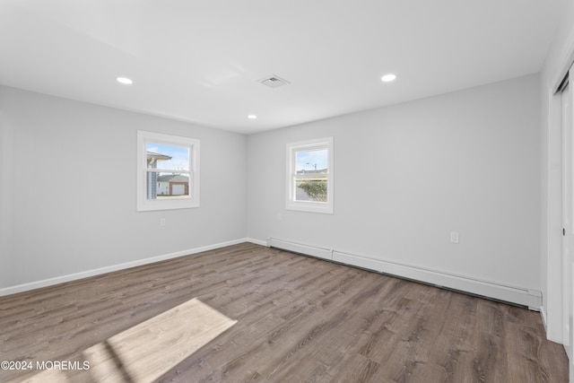 empty room with a baseboard radiator and wood-type flooring