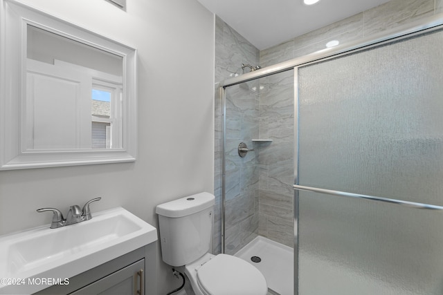 bathroom with vanity, an enclosed shower, and toilet