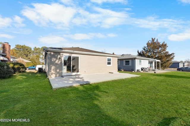 rear view of property with a lawn and a patio area