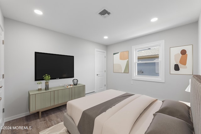 bedroom featuring wood-type flooring and a baseboard heating unit