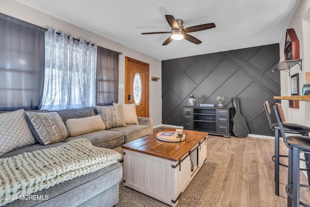 living room with light hardwood / wood-style flooring and ceiling fan