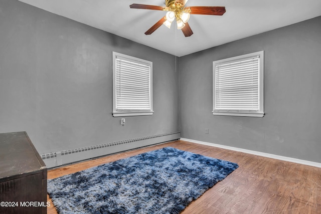 unfurnished room featuring ceiling fan, a baseboard radiator, and hardwood / wood-style flooring