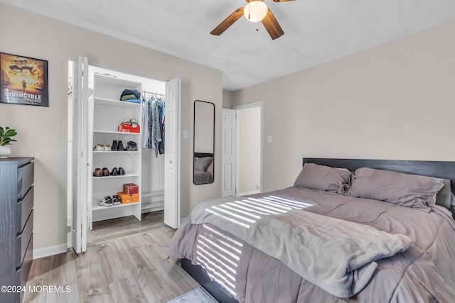 bedroom with a closet, light hardwood / wood-style flooring, and ceiling fan