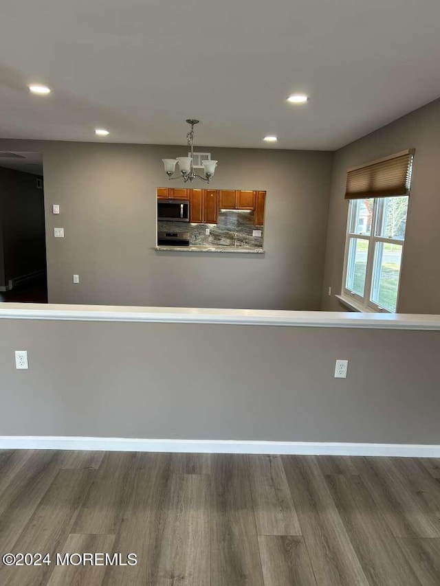 interior space with hardwood / wood-style flooring, tasteful backsplash, and a chandelier