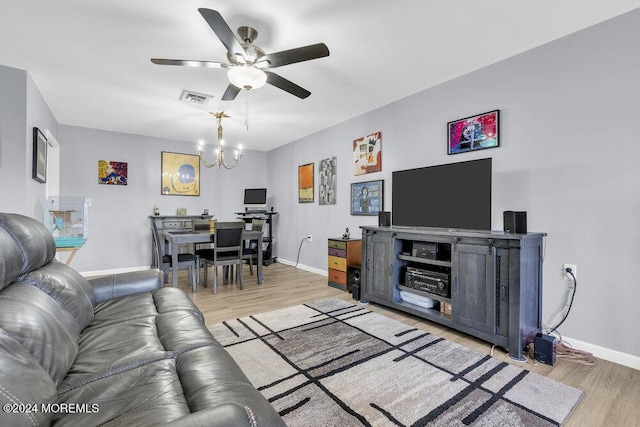 living room featuring ceiling fan with notable chandelier and wood-type flooring