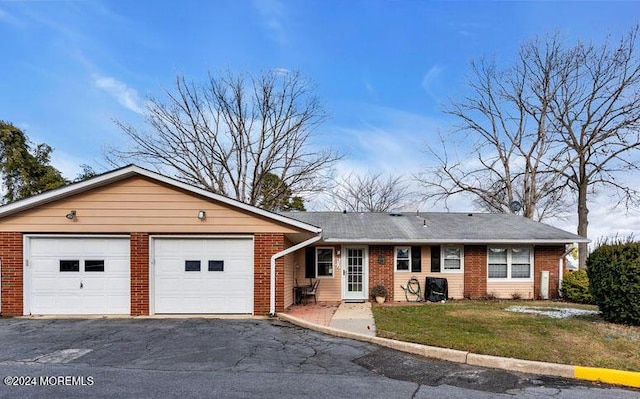 ranch-style house featuring a front yard and a garage