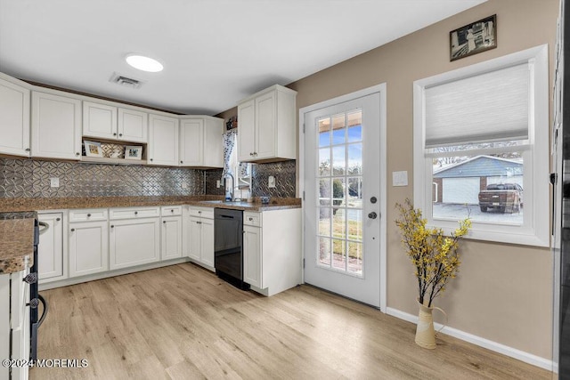 kitchen with sink, dishwasher, light hardwood / wood-style flooring, dark stone counters, and white cabinets