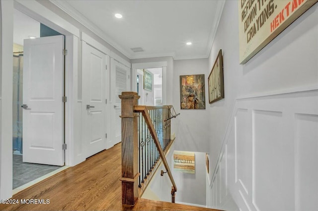 hall with hardwood / wood-style flooring and ornamental molding