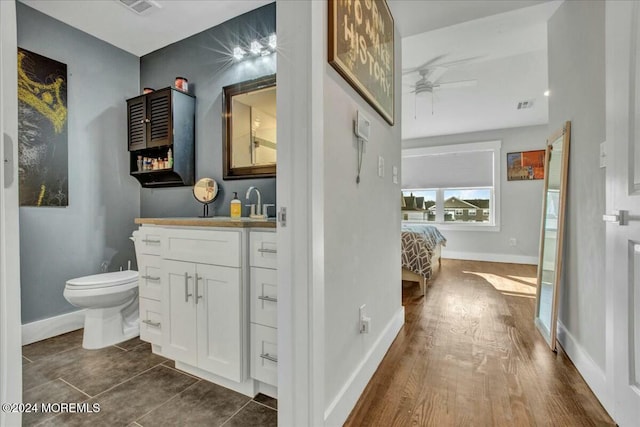 bathroom featuring hardwood / wood-style floors, ceiling fan, toilet, and vanity