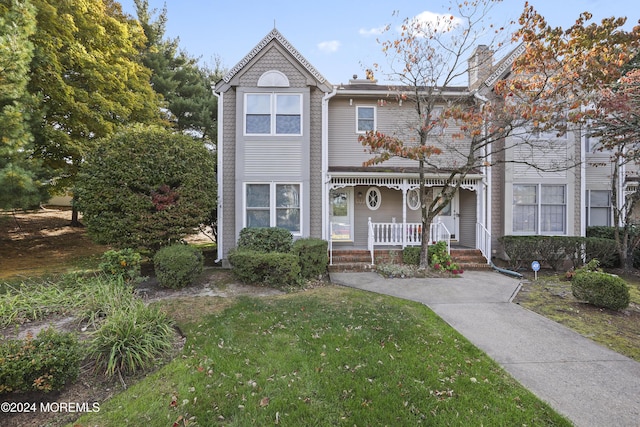 view of front of property with a porch and a front yard