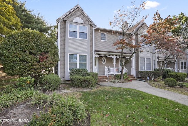 view of front of house with covered porch and a front lawn