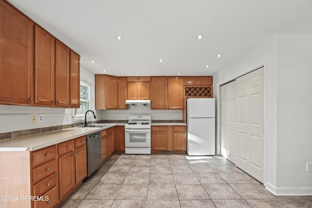 kitchen featuring white appliances, sink, and light tile patterned floors