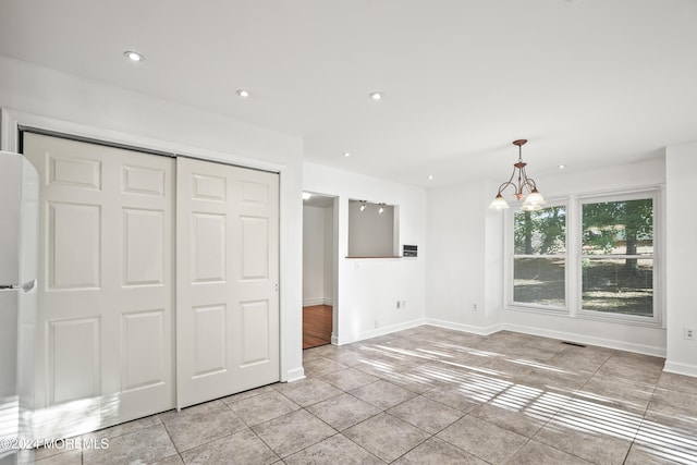 interior space with an inviting chandelier, a closet, and light tile patterned flooring