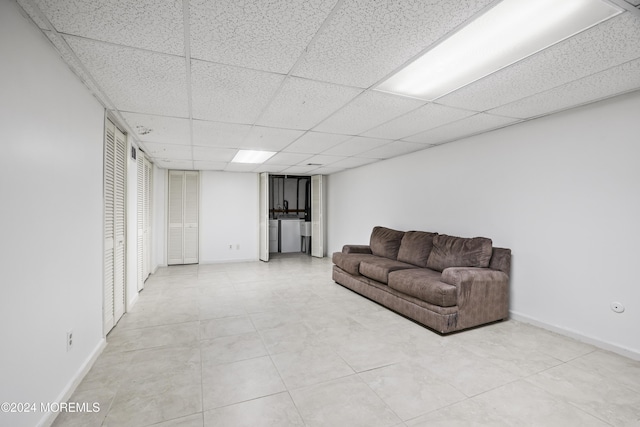 living room featuring separate washer and dryer and a drop ceiling