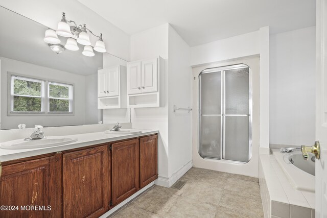 bathroom with vanity and shower with separate bathtub