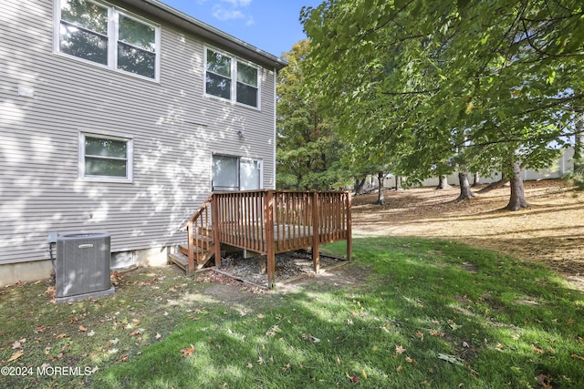 back of property featuring a yard, cooling unit, and a deck