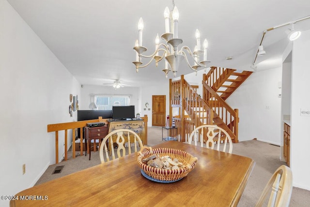 carpeted dining room featuring ceiling fan with notable chandelier