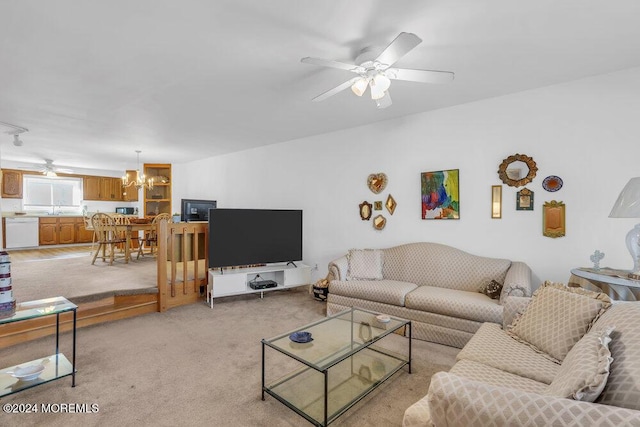 carpeted living room with ceiling fan with notable chandelier and sink