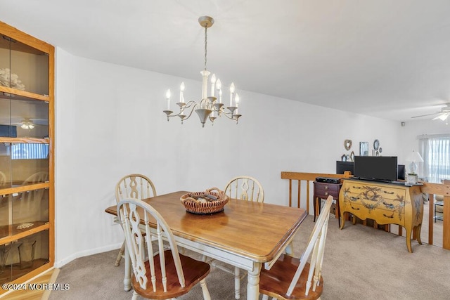 dining space with ceiling fan with notable chandelier and light colored carpet