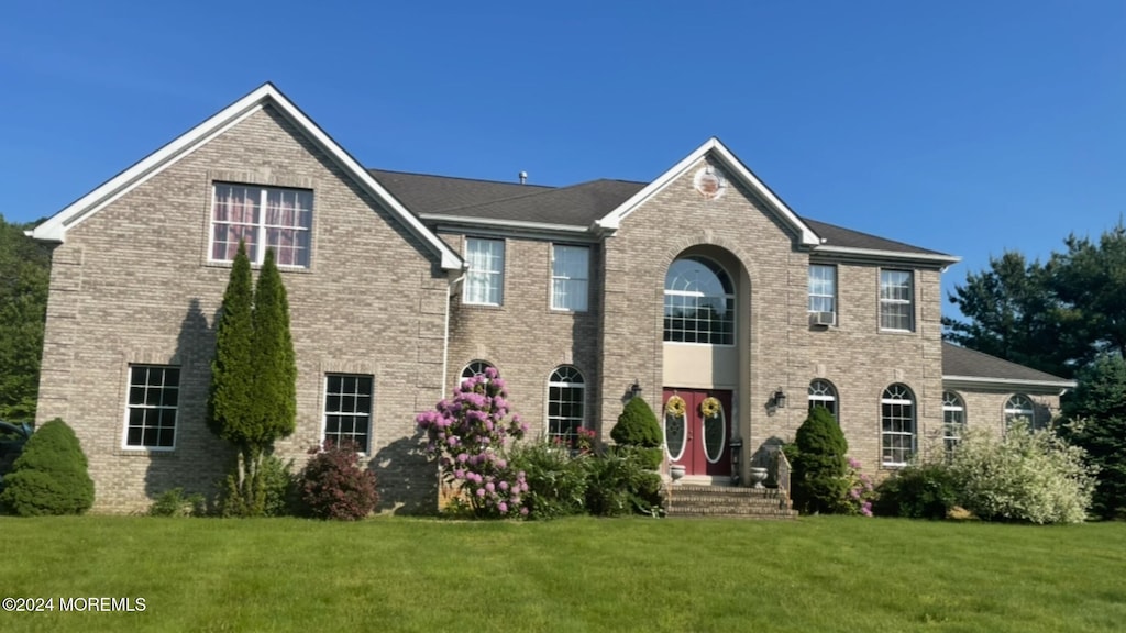 colonial inspired home featuring a front yard