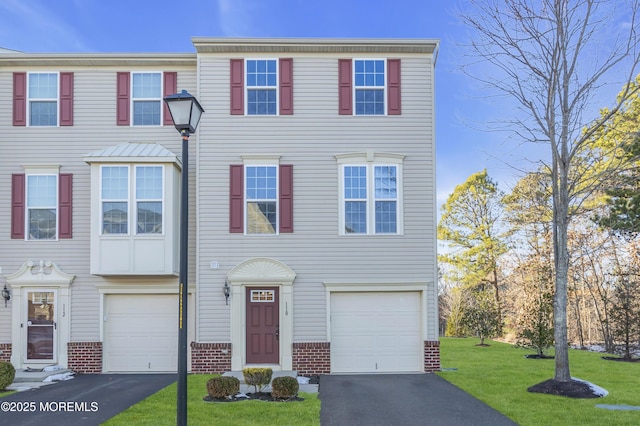 townhome / multi-family property with a garage and a front lawn