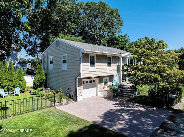 bi-level home featuring a garage and a front lawn