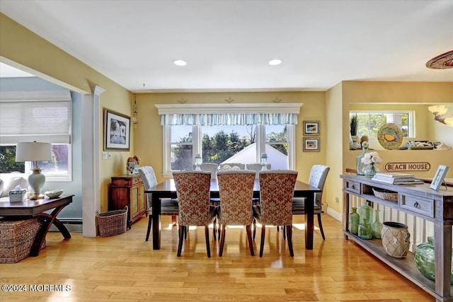 dining space with light hardwood / wood-style floors and a baseboard heating unit