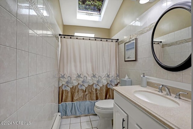 full bathroom with baseboard heating, tile patterned flooring, lofted ceiling with skylight, vanity, and tile walls