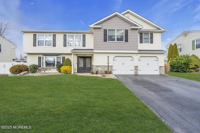 view of front of home with french doors, a garage, and a front lawn