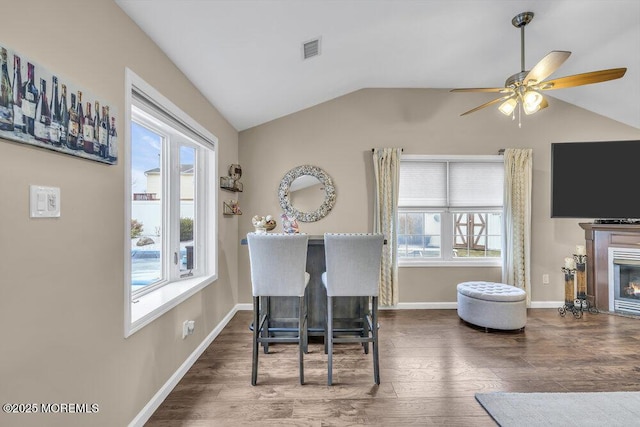 dining room with a healthy amount of sunlight, ceiling fan, dark hardwood / wood-style floors, and lofted ceiling