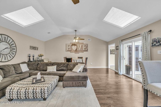 living room with ceiling fan, hardwood / wood-style floors, and lofted ceiling with skylight