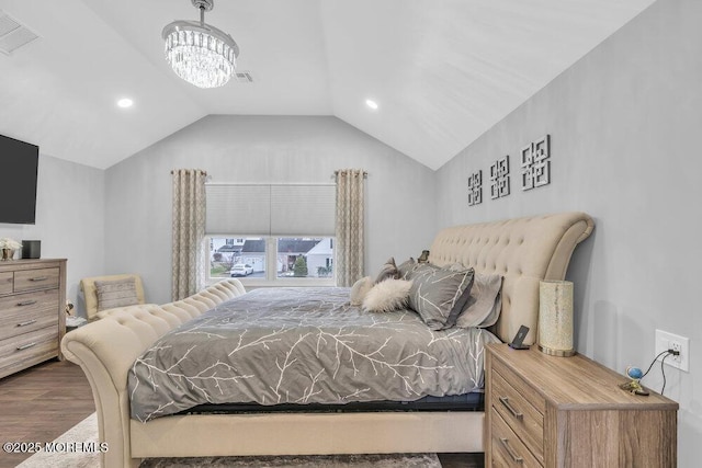 bedroom featuring dark hardwood / wood-style flooring, lofted ceiling, and an inviting chandelier