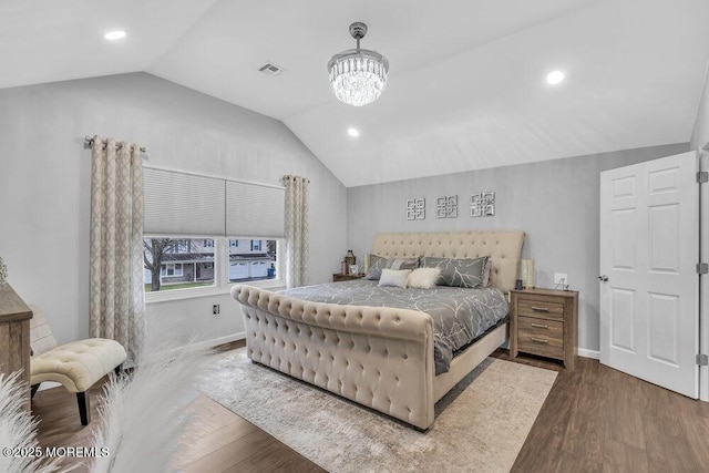 bedroom with wood-type flooring, vaulted ceiling, and a notable chandelier