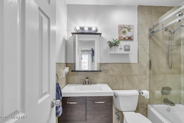 full bathroom with vanity, toilet, shower / bath combination with glass door, and tile walls