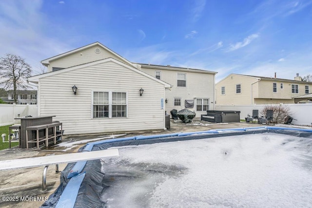 rear view of house featuring a hot tub