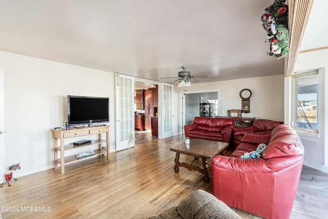 living room featuring ceiling fan, wood-type flooring, and french doors