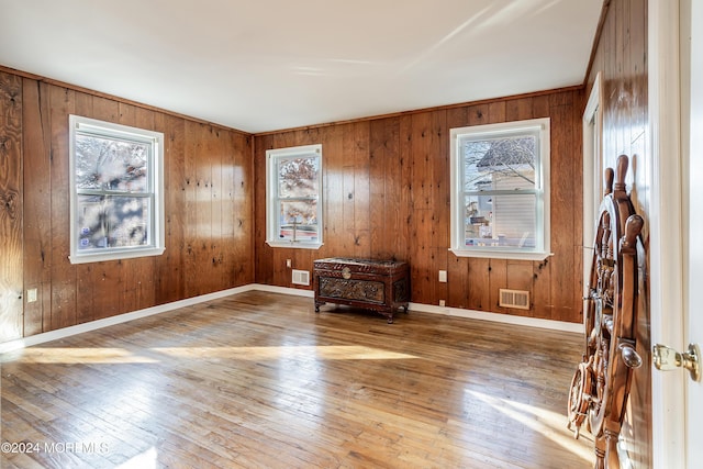 empty room featuring hardwood / wood-style floors and wooden walls