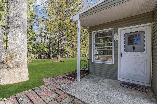 entrance to property with a lawn