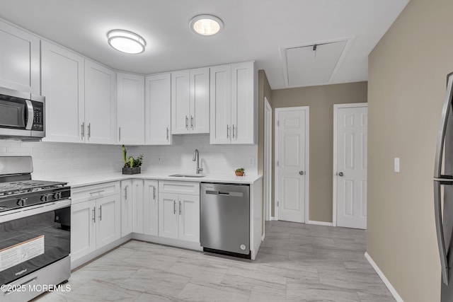 kitchen with decorative backsplash, stainless steel appliances, white cabinetry, and sink