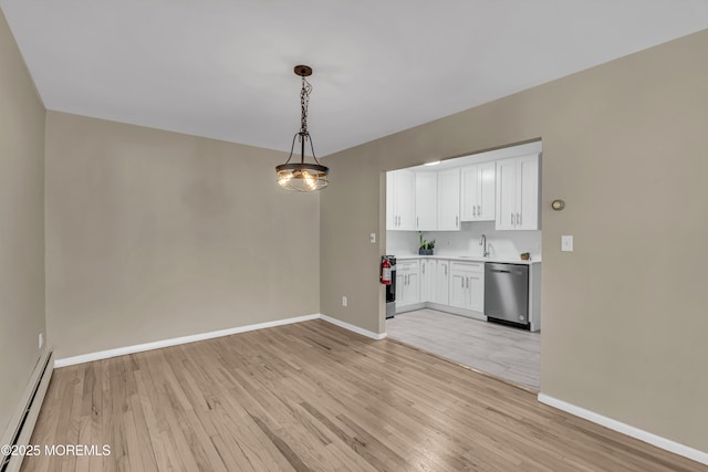 unfurnished dining area with sink, light wood-type flooring, and a baseboard heating unit