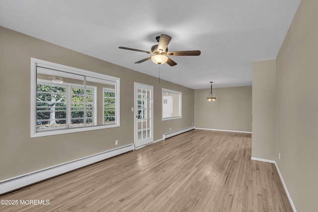 spare room featuring light hardwood / wood-style flooring, baseboard heating, and ceiling fan