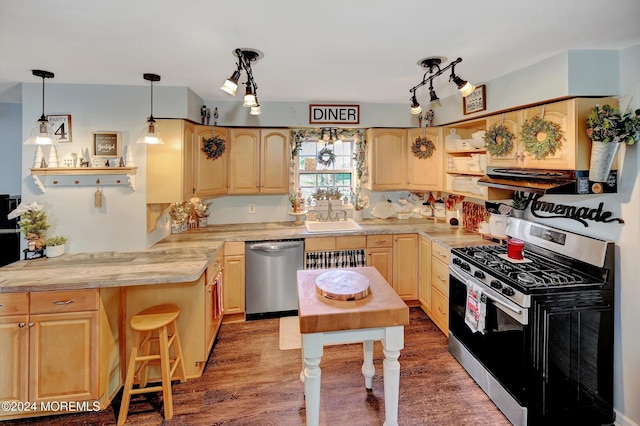 kitchen with stainless steel appliances, light brown cabinetry, and sink