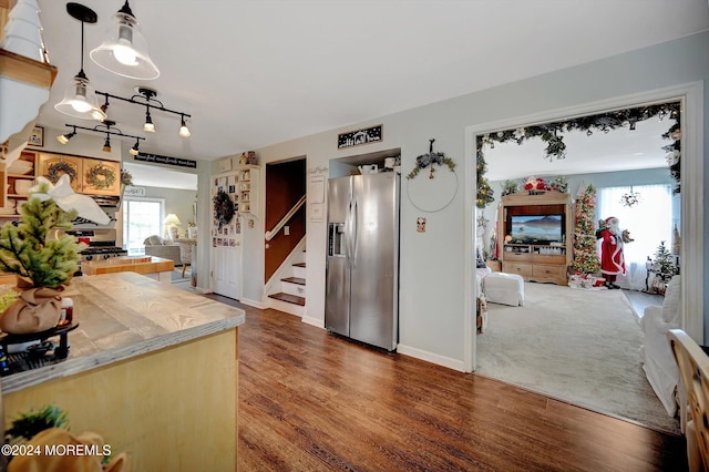 kitchen featuring dark wood-type flooring, stainless steel fridge with ice dispenser, and hanging light fixtures