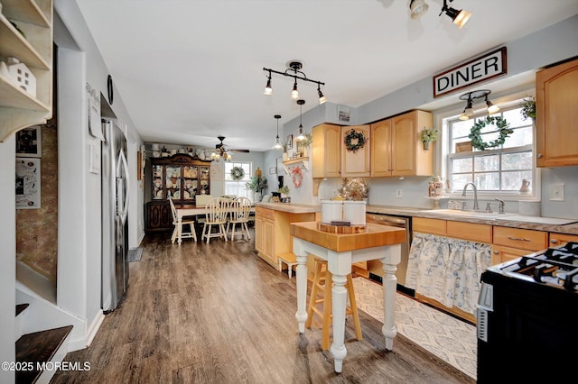 kitchen featuring a healthy amount of sunlight, decorative light fixtures, dishwasher, and sink